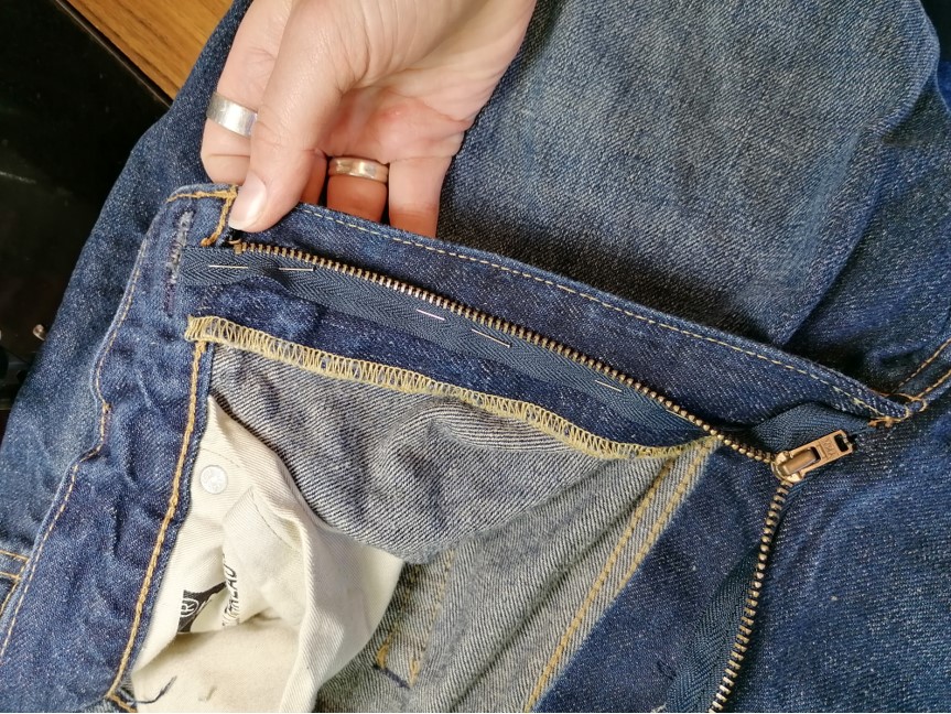 Advice for fixing new jeans: Brand new pair of jeans had the decorative  thread come undone near the left pocket (See photo). Any suggestions on how  to mend it? I have access